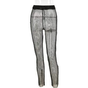 Detail of high-waisted black mesh pants featuring sparkling rhinestones and hollow fishnet