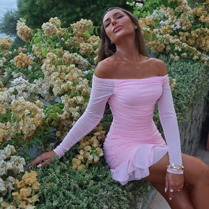 Détail de la robe courte rose à épaules dénudées en mesh plissé avec ourlet à volants