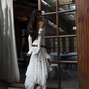 Detailed back view of a white backless mini dress with lace trim hem and thin belt