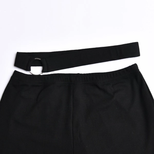 Detail of black ribbed fabric with waist cutout design and a silver metal O-ring accent
