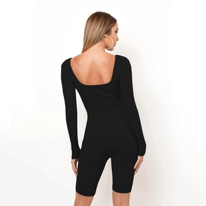 Rear view of black ribbed long sleeve jumpsuit with backless U-neck and biker shorts