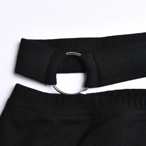 Detailed close-up of ribbed knit fabric featuring a decorative silver metal ring connector