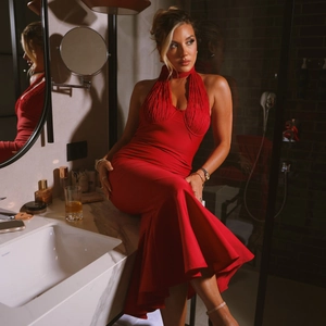 Détails de la robe dos nu rouge avec bustier plissé et ourlet style sirène