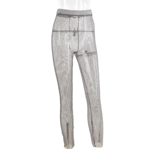 Close-up of sparkling rhinestones on sheer silver mesh fabric of high-waist trousers