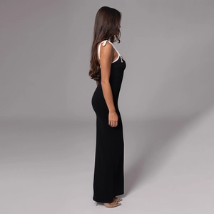 Close-up of black bodycon maxi dress featuring contrasting white straps and trim details