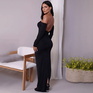 Detail of the elegant open back and sleek side slit on a black off-shoulder maxi dress