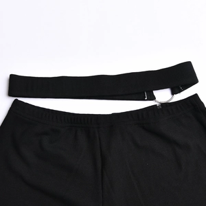 Detailed view of black ribbed knit pants featuring a silver ring buckle and waist belt detail