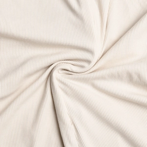 Gros plan d'un tissu en maille côtelée blanc crème avec texture douce et rayures verticales