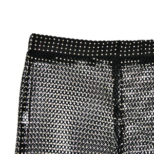 Detail shot of black fishnet mesh pants with shimmering colorful rhinestones and elastic waist