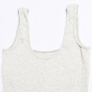 Detail of light grey ribbed knit fabric texture with U-neck and wide shoulder straps