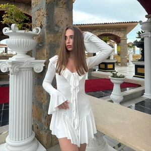 Detail of white V-neck mini dress with ruffled trim and elegant flared sleeves