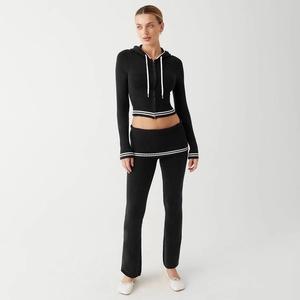 Detail view of knitted two-piece set featuring striped elastic waistband and cuffs