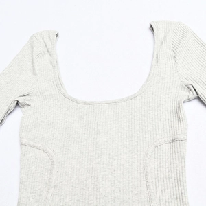 Macro detail of heather grey ribbed knit fabric and U-neck stitching on the bodysuit