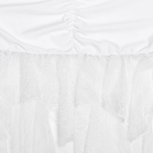 Macro shot of the white ruched fabric texture and delicate multi-layer lace dress hem