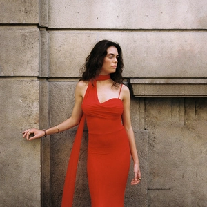 Détail de la robe rouge moulante avec écharpe nouée et bretelles asymétriques