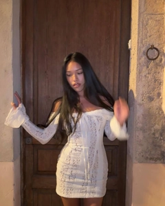 Détails de la robe en dentelle blanche à épaules dénudées et manches longues évasées