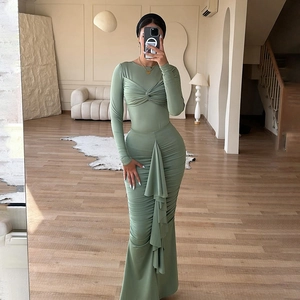 Détail de la robe froncée vert sauge avec nœud devant et ourlet à volants élégant