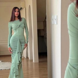 Détail de la robe maxi vert sauge avec fronces et nœud frontal pour une coupe ajustée