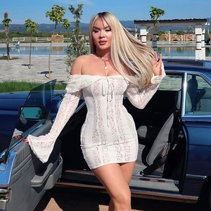 Détail de la robe en dentelle blanche avec col bardot, manches cloche et coupe moulante chic