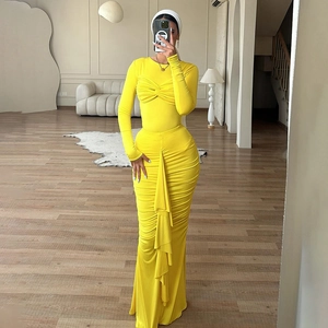 Détail de la robe moulante jaune vif avec buste torsadé et texture froncée élégante