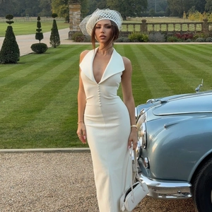Détail d'une robe blanche élégante à col en V avec boutons recouverts et style raffiné