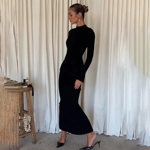 Detail of the high-slit hem and slim fit design of this black long sleeve maxi dress