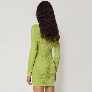 Detail view of the vertical ruched stitching on the back of the slim-fit green mini dress