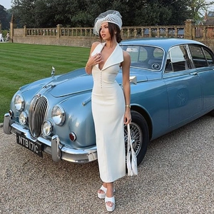 Détail d'une élégante robe blanche à licou avec décolleté en V et rangée de boutons