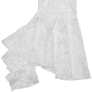 Détail du tissu en dentelle florale blanche avec broderie ajourée et volants superposés