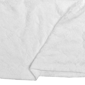 Gros plan sur le tissu en dentelle florale blanche montrant la texture délicate