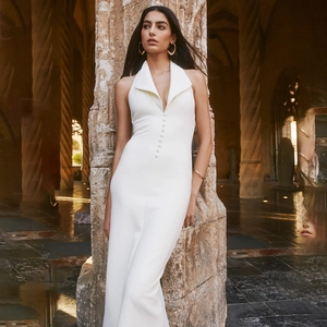 Détail de la robe licou blanche avec décolleté en V profond et boutons décoratifs à l'avant