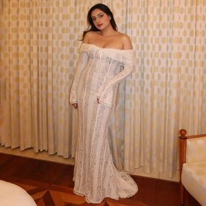 Dettaglio della manica in pizzo floreale e vita elegante sull'abito lungo bianco