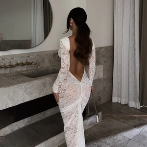 Detail of elegant white lace dress featuring deep V backless design and ruched mermaid hem