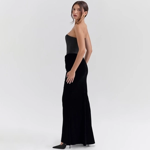 Detail of elegant black strapless corset dress with high-waisted velvet maxi skirt