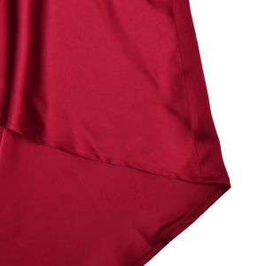 Dettaglio dell'orlo in raso rosso scuro con cuciture precise e finitura lucida