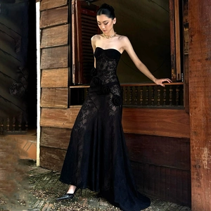 Detailed texture of black strapless lace evening gown with 3D floral accents