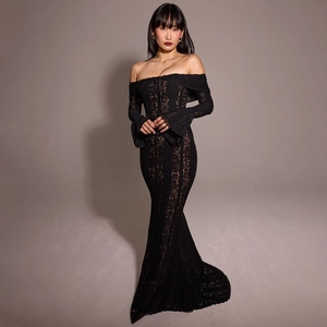 Dettaglio dell'elegante abito in pizzo nero con spalle scoperte e maniche a tromba