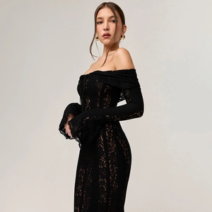 Dettaglio del vestito nero in pizzo con spalle scoperte, motivi floreali e maniche