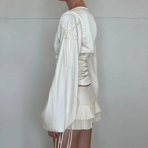 Ensemble haut en satin crème à manches longues avec nœuds et mini-jupe plissée