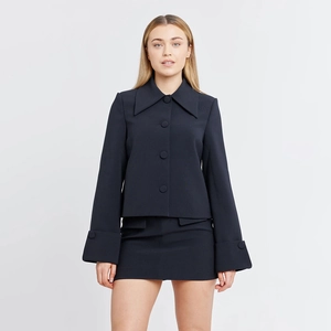 Detail view of navy blue two-piece set featuring large pointed lapel and matching buttons
