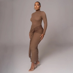 Détail de la texture plissée marron foncé et de la ceinture nouée sur la robe longue