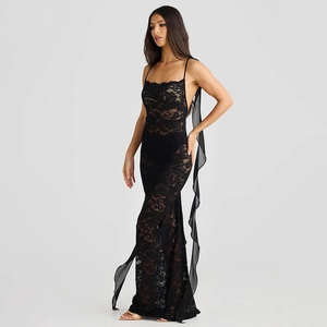 Détail d'une robe en dentelle noire avec motifs floraux ajourés et volants en tulle