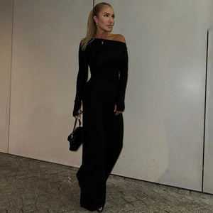 Detail of black off-shoulder jumpsuit with long sleeves and thumbhole cuffs
