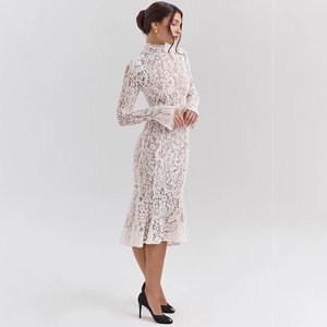 Detail shot of the elegant floral lace texture and mermaid hem of the white dress