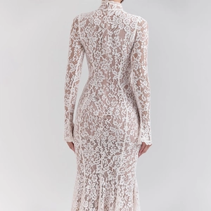 Detailed view of the sheer floral lace fabric and back zipper on a slim white dress