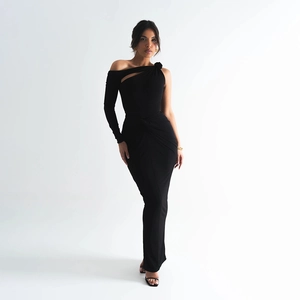 Detail of elegant black one-shoulder dress with floral accent and asymmetric cutout