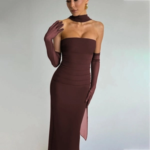 Dettaglio dell'elegante abito a tubino bordeaux con texture a pieghe e guanti abbinati