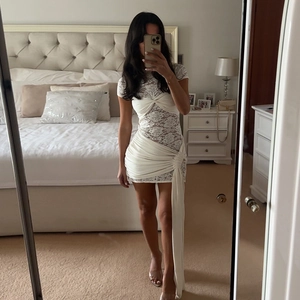 Elegant white lace bodycon mini dress featuring chest knot and long side ribbons