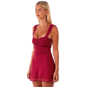 Rotes Polka-Dot-Minikleid mit Spaghettiträgern und Knotendetail vor weißem Hintergrund