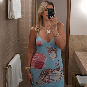 Detail of the light blue sun dress featuring ocean shell prints and a slim fit cut